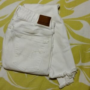 Size 2 Low Waist American Eagle White Frayed Skinny Jeans.